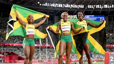 Shelly-Ann Fraser-Pryce, Elaine Thompson-Herah and Shericka Jackson of Jamaica celebrate after completing a podium sweep in the women's 100m final on Day 8 of the Tokyo Olympic Games.